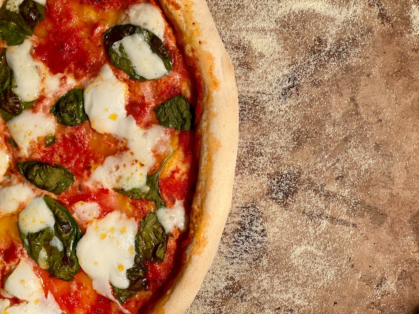 Pizza met mozzarella en basilicum net uit de oven